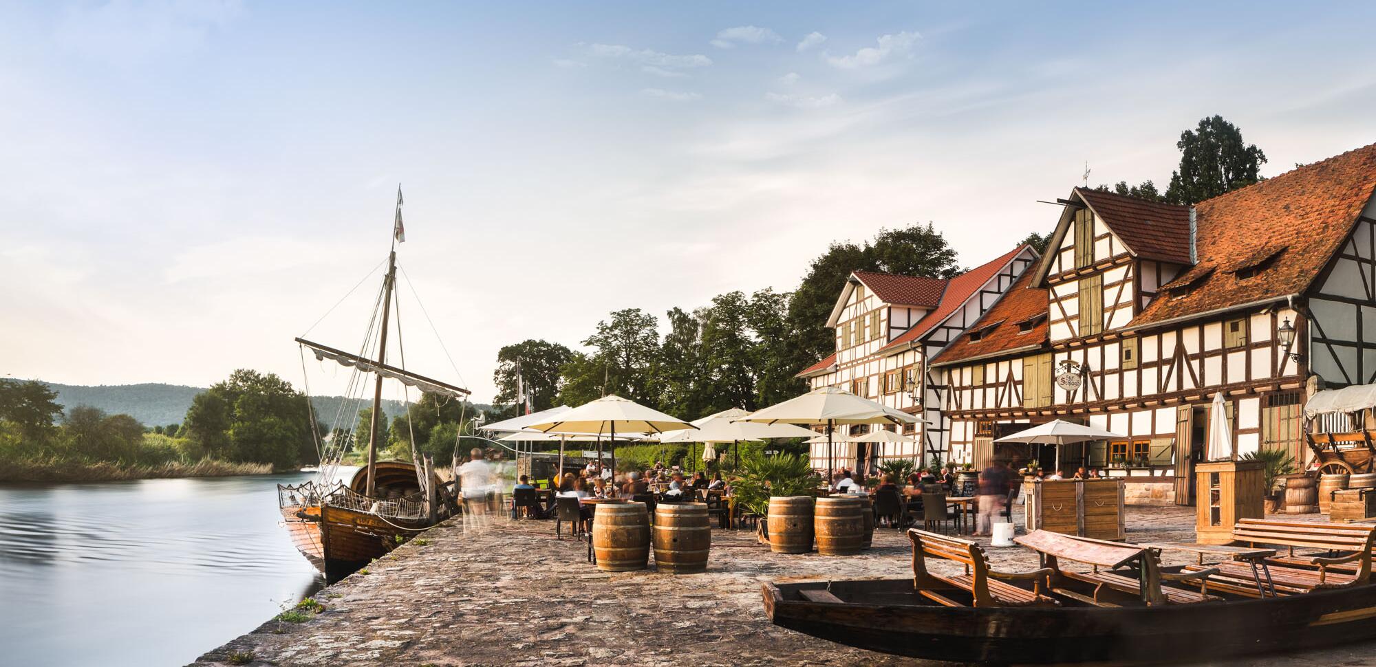 Historischer Hafen "Schlagd" mit Biergarten, Fachwerkhaus und altem Segelboot in Wanfried