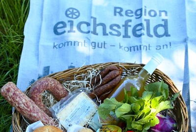 Spezialitäten des Hoflandens in einem Korb auf einer Wiese
