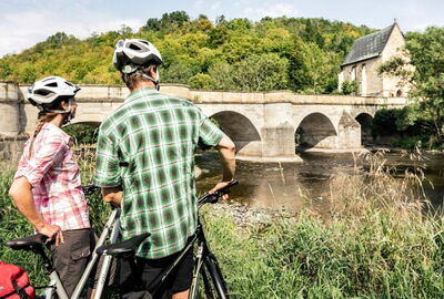 Radfahrer auf dem Werratal-Radweg mit der Werratalbr?cke in Creuzburg im Hintergrund