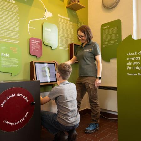 Naturpark-Mitarbeiterin im Gespräch mit Besucher der Naturpark-Ausstellung