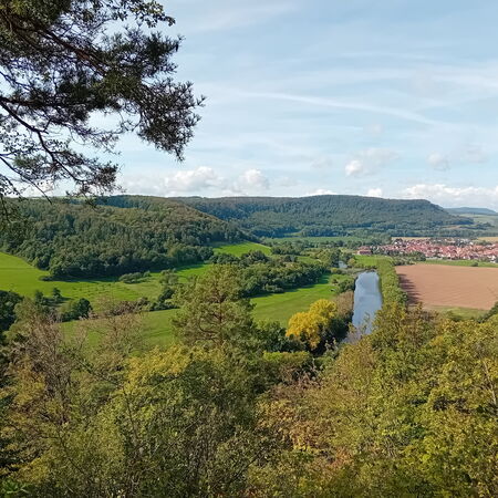 Blick auf die Werra von einem erhöhten Punkt. Im Hintergrund der Ort Falken im Naturpark Eichsfeld Hainich Werratal.