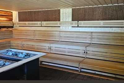 Fertigung und Montage einer öffentlichen Großraumsauna aus Abachi-Massivholz. Saunabänke/Lehnen, Decken/Wandpaneele und Handläufe aus unserem Hause