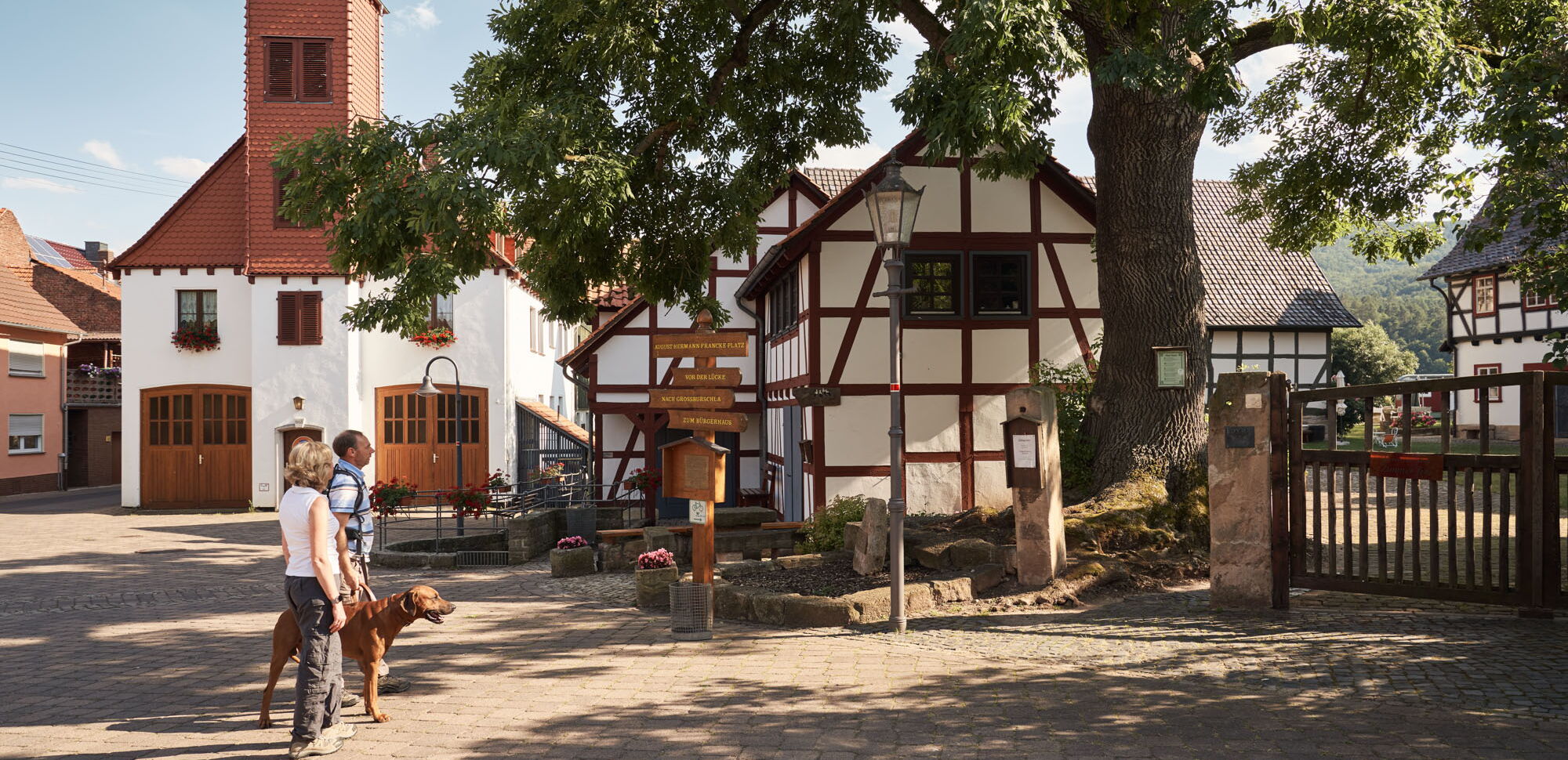 Wanderer mit Hund im Ortskern von Heldra