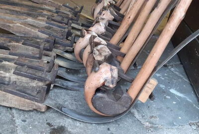 Historische Werkzeuge und Holzformen zur Herstellung von Wanderst?cken liegen und stehen in einer Werkstatt bereit. Zu sehen sind gebogene Metallformen und eingespanntes Holz, die f?r das Formen der charakteristischen Stockgriffe verwendet werden.