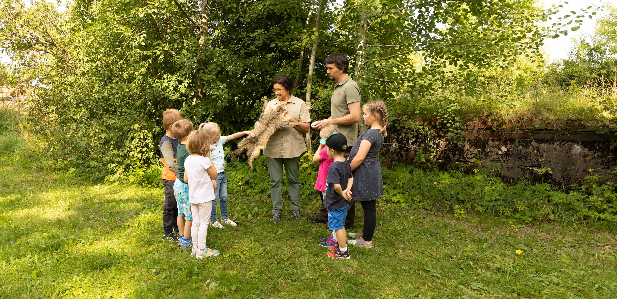 Beim Umweltbildungsprogramm zur Wildkatze zeigt eine Mitarbeiterin vom Naturpark den Kindern ein Fell einer Wildkatze