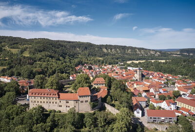 Blick auf Creuzburg mit der gleichnamigen Burg im Vordergrund. Im Hintergrund sind die Felsen der Ebenauer Köpfe zu sehen.